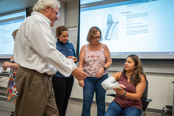 A professor teaching how to wrap an arm